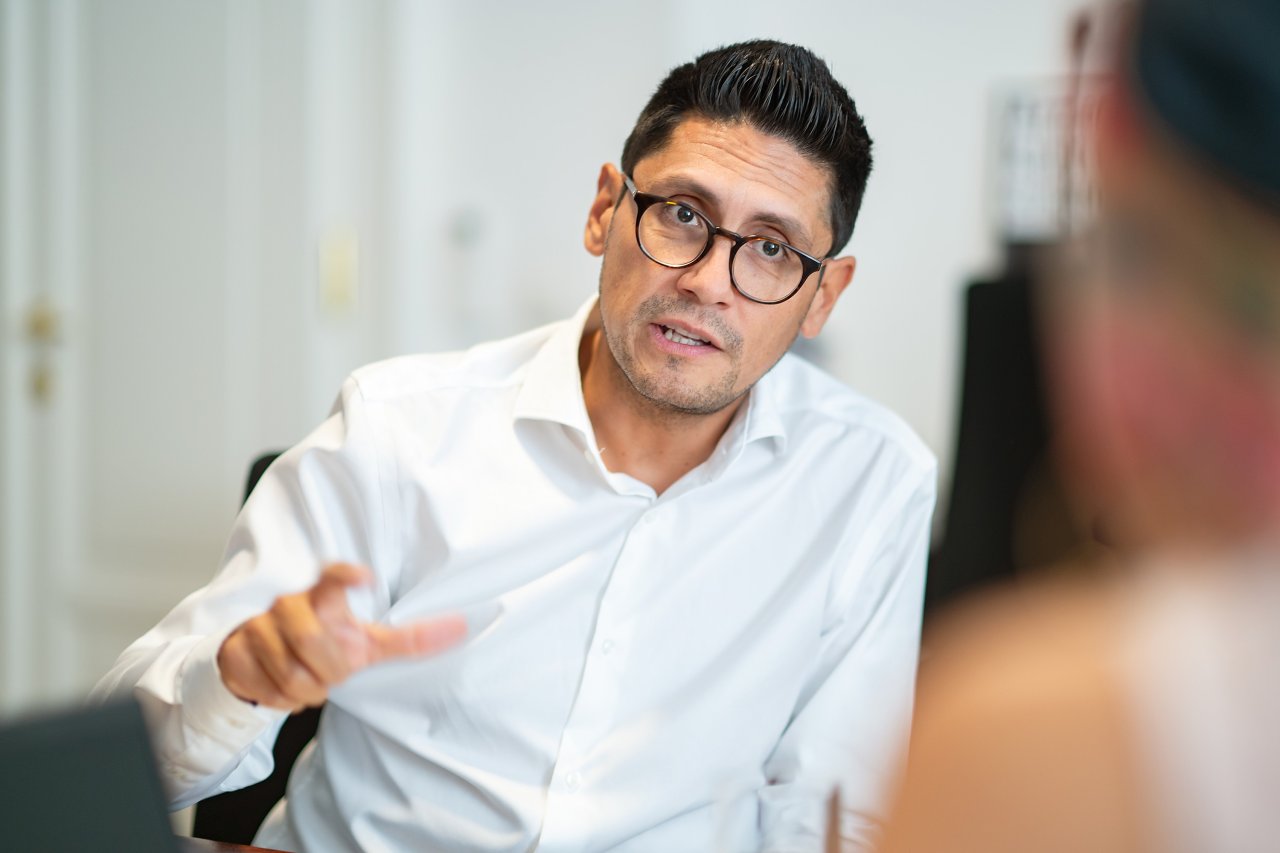 Mann mit weißem Hemd am Schreibtisch