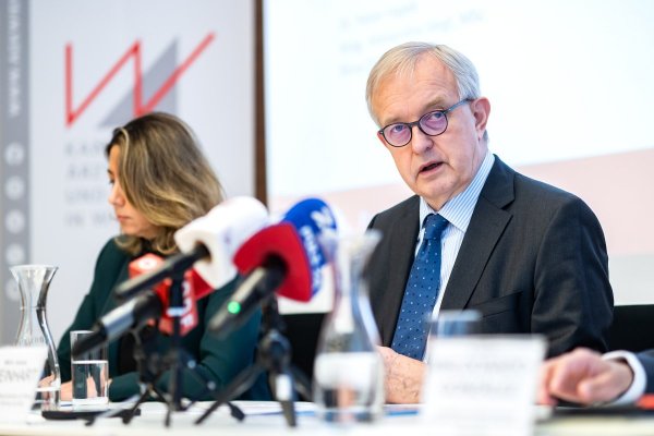 Eine Frau und ein Mann an einem Tisch, auf dem zahlreiche Mikrofone stehen.