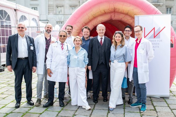 Personengruppe vor überdimensionalem Darm-Modell stehend.