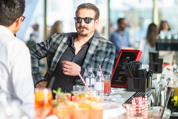 Zwei Männer an einem Stehtisch auf der Terrasse im Gespräch.