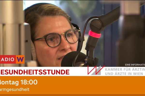 Screenshot, das eine Frau in einem Radio-Studio vor einem Mikrofon zeigt.