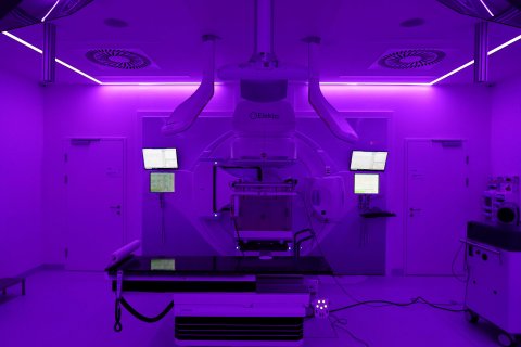 Ein Foto von einer Radioonkologie-Strahlenanlage - der Raum ist in violettes Licht getaucht.